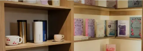 Estantes de la librería con libros, tazas y termos