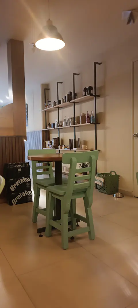 Rincón con sillas verdes y repisas