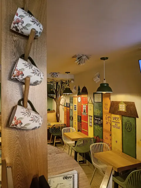 Rincón con tazas colgadas y mural de casitas